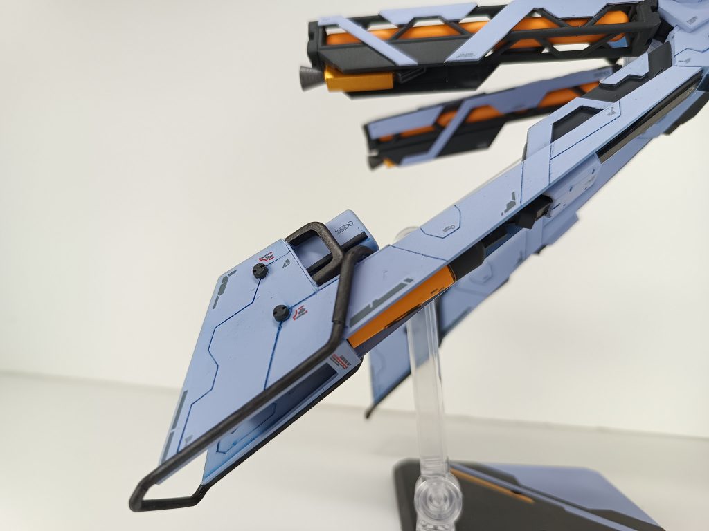 後方からと脚部プロペラントタンク開閉このドラッツェの特徴的と言える1番やりたかった部分です。脚部は特にジークアクスの世界観を意識してスクラッチしました。イメージ構成としてはドラッツェのプロペラントタンク＋ジークアクスの世界観＋建物の構造物＋エヴァ÷2と言った様な具合で脚部をデザインしました。脚部上部のトラス型の中に入ったプロペラントタンクがジークアクスに合いそうだなぁ、と1番最初に手を出した部分です。展開して収納されている下部スラスターをスライド展開させる事で高速戦闘が可能になります。脚部後方もジークアクス全体の特徴と言えるパイプを這わせて作品に寄せてるように見せています。脚部全体も情報量増しの為にコーションデカールと筋彫りを施しています。若干見え辛いですが、バックパックも脚部同様にドラッツェのデザインを踏襲しつつもジークアクス特有のパイプの配置とデザインを取り入れて、スクラッチとミキシングを施しています。