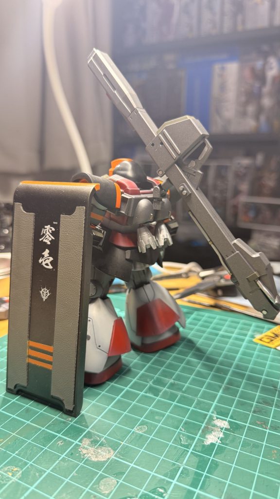 ミリアを脱出艇へ向かわせた後、ドム・レジリエンスは通路の中央に立ち、侵入してくるモビルスーツの火線を受け止め続けた。直撃弾で左肩装甲が砕け、ホバーは不調をきたし、警告音が機内に満ちていく。それでも男は後退しなかった。通信越しに届いた最後の声――「生きていて」と言うミリアの震える言葉が、彼の中で何度も反響する。彼は答えなかった。ただ前を向き、彼女がもうこの戦場を去ったと確信できる瞬間まで、引き金を引き続けた。