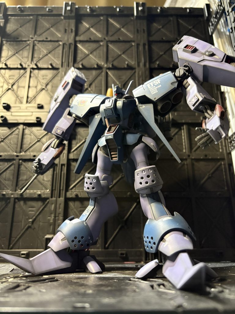 設定として、トリントン基地所属の機体。成層圏での運用をするため、試験的に脚部の変更、背中に追加ブースターとプロペラントタンク、スラスターの補強、肩のスラスターにミサイルポッド追加、マニュピレーターの変更を行っている。