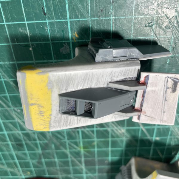 イメージはWWⅡ時代の戦車。現地改修風の装甲追加や高速ホバー移動であれば空力も必要であろう、エアインテークも必要であろうと肩は自作&ジャンクパーツで固めました。ボディ後部のアンテナはスモークディスチャージャーに置き換え。無くしたアンテナは別な方法で復活させてますが、それはまた次回にでも。足元を確認するためには下方用のカメラも必要であろうとスコタコ風にでっちあげ！（3枚目）