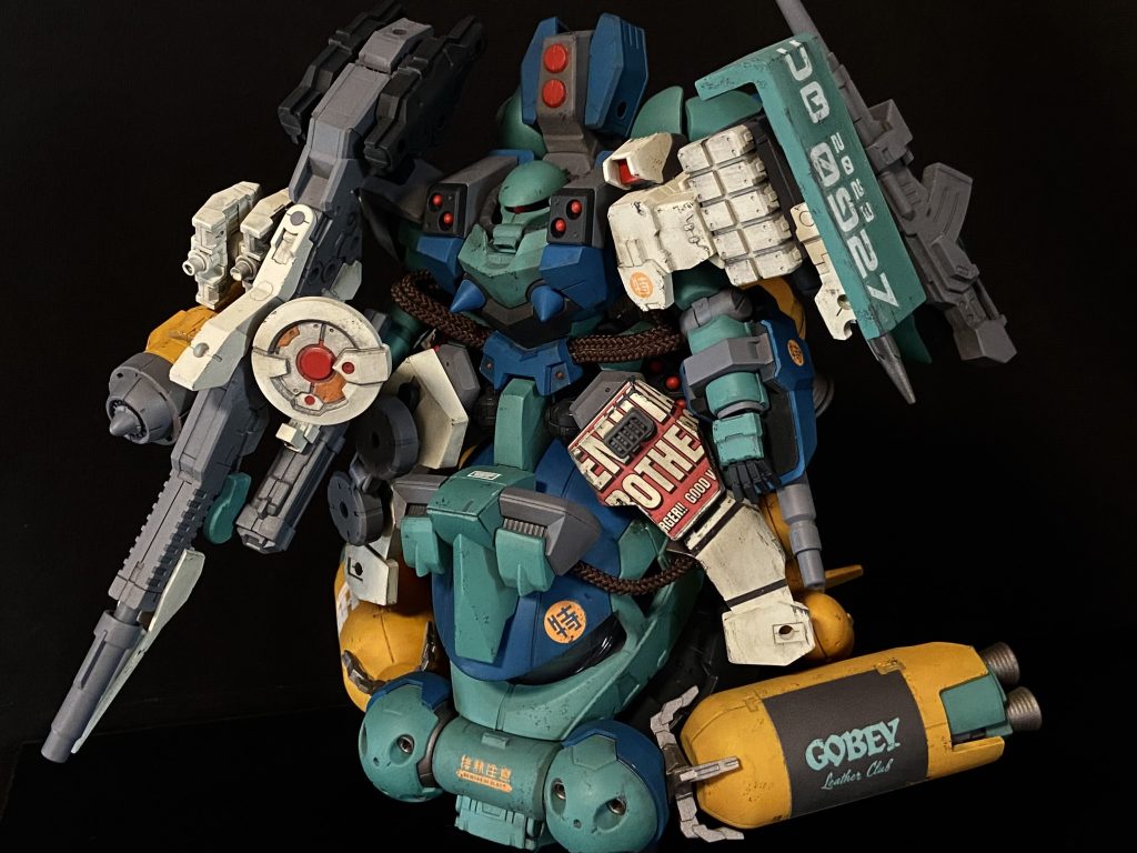 ハイパーカスタムザクF2000UBと名付けた本作は、スーパーカスタムザクF2000をベースにゴテ盛り改造したザクです。ガンプラを中心に色んなキットからパーツを拝借し、お店特製ステッカーを貼って仕上げました!