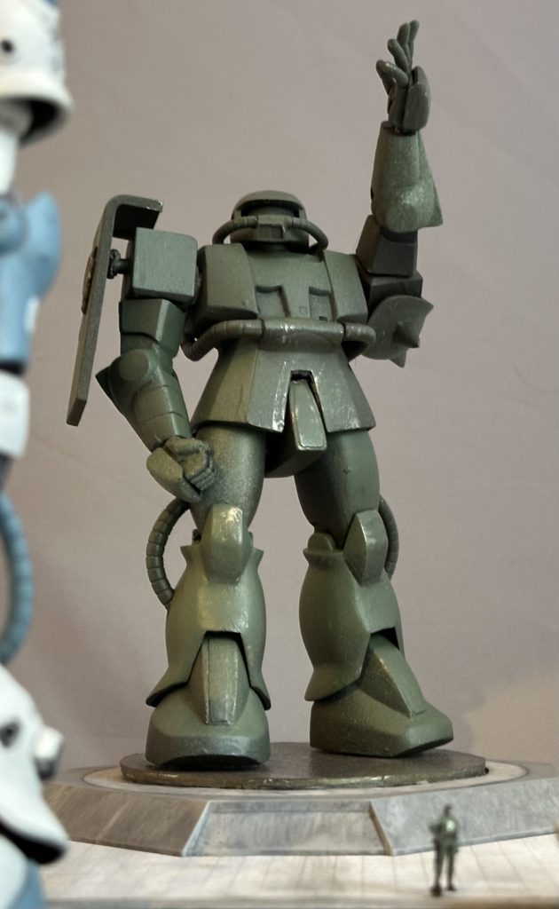 キットプロポーションを活かしつつ、関節はアルミ線接続に置き換えて、より自然なポージングが出来るようにしてあります。手首だけはビルダーズパーツに置き換えました。旧キットと現行キットの「同じ世界線」での共存を考えた結果、旧キットを「ブロンズ像」にしてみました。現行キットのFやFIIやFZを「実機」とし、旧キットは「彫刻家がザクを独立の象徴として力強く頼もしい戦士としてマッシブに誇張した姿」を表現した「芸術作品」にしてみました。いかがでしょう？