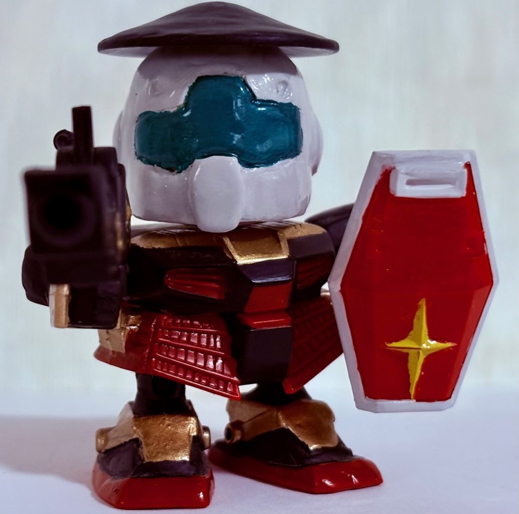 種子島バルカンとシールドを装備した状態。戦国時代に入り、集団戦が本格化・大規模化していくと、訓練された長槍・弓・鉄砲の足軽隊が組織され主要な部隊として活躍するようになり、足軽の兵力が戦いを大きく左右する事になった。つまりドズルの「戦いは数だよ」発言や連邦軍の物量作戦は歴史的に見て正しい戦法なのである。