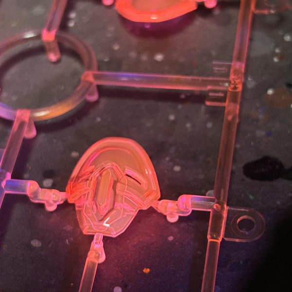 クリアピンクのパーツがありますが、UVライトを当てると赤みが強めに発光します。蛍光ピンクに蛍光クリアや蛍光ブルーを混ぜるとピンクに発光するので、調色した蛍光ピンクで塗装してみたら、地の蛍光ピンクが強く赤みが思っていた以上に出てしまったので、直接蛍光クリアーを塗ってみました。かなり、いい感じのピンクに発光するようになりました。クリアピンクのパーツには蛍光クリアーですね。（2枚目）