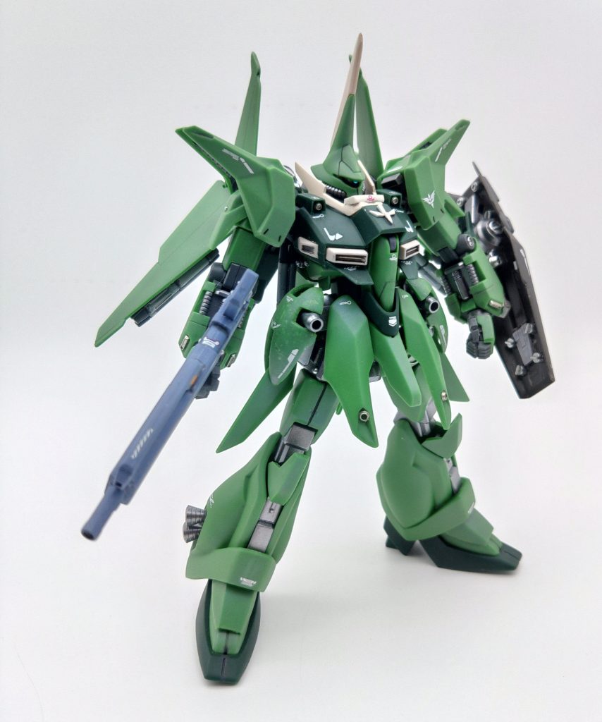 量産型バウと袖付きバウの設定の違いは襟のガード、肩のマシンガン、両腕の袖が付くグレネードユニット、腰のサイドアーマー、バウナッターの機首、ライフルとシールドです。(腰のフロントアーマーの長さや股間のバーニアが無いなど細かく見ていくとキリがない)改造点といってしまってはなんですが、リバウを潰せば結構なんとかなってしまうのですが、今となってはリバウの入手難易度がなかなかに高いのが泣き所です。しかしシールドとライフルを除けば量産型バウからの改造でなんとかなるので、みんな大好き流行りの成型色仕上げでバウ袖付きを作る人がいた場合、仮にも、万が一いてしまった場合に、その時には役にたつかもしれないので、ここに改造点を書き残しておきます。 ・頭部トサカの形状をカラープラ板を貼って直線的にする。モノアイをくり貫いてパイプを入れて可動にする。モノアイは緑なのですが、本体色を加味して青のHアイズを使用、本体色の反射で青みがかった緑に見える。 ・胸部襟にリバウで余るバウの踵パーツを切り出して貼る。肩のマシンガンをカラープラ板で作成胸中央のエンブレムをプラ板で作成肩の付け根パーツ切り離して2ミリ上に再接着 ・腰部リバウの余剰パーツの腰部を使用サイドアーマーはカラープラ板で基礎となる箱を組んで、そこにヒートペンでランナーを溶かしながら盛り付けて形を出す。バウナッターの機種をカラープラ板箱組で作成、ネオジム磁石で脱着式にする。 ・腕部グレネードランチャーを中央で切断し、上にカラープラ板を貼って延長+カラープラ板で袖の基部を作成袖のエングレービングは細切りプラ板を組み合わせて作成 ・ライフルHGUCのレズンギラドーガが入手困難だったので、旧キットのギラドーガの指揮官用ライフルをカラープラ板で幅増し持ち手をカラープラ板で延長、これで保持が安定しつつバウアタッカー時の接続部となる。旧キットギラドーガなら、ライフルが豊富に付属しているので、拝借しても一般機として組めるので精神的にも良い ・シールドリバウのシールドでは回りに付属品がついているので、必要箇所を切り出して使用 その他はディテールパーツを使ったりシャープ化したりしております。はい