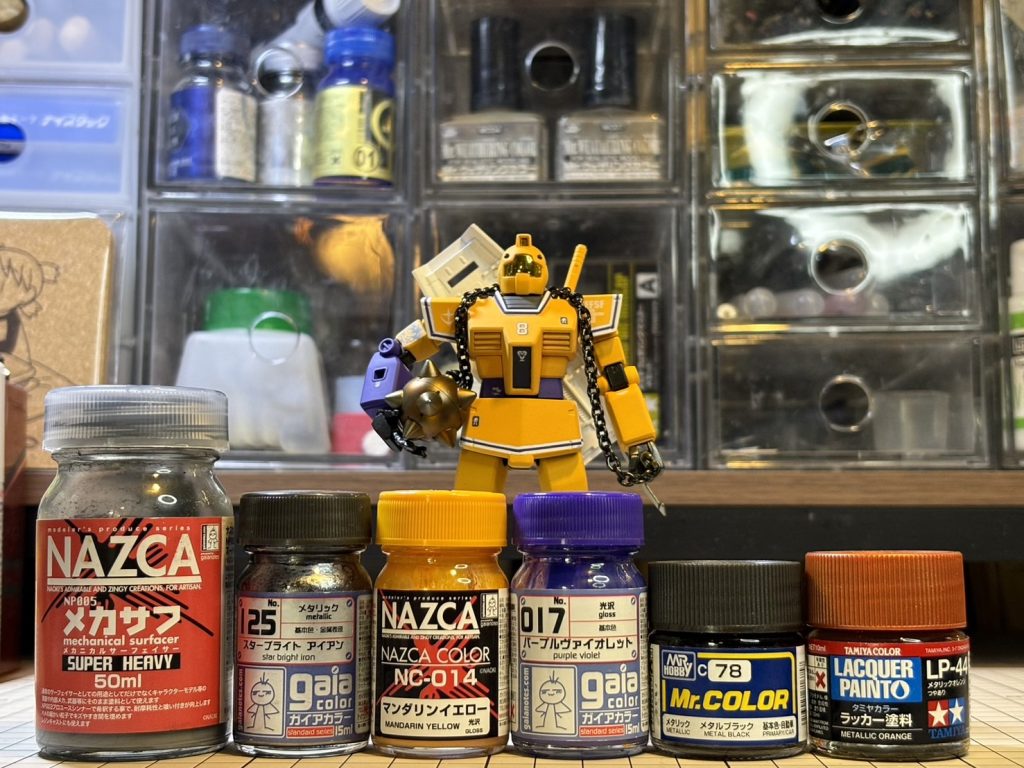塗料備忘録本体：ガイア　マンダリンイエロー／パープルヴァイオレット／アルティメットホワイト襟元・コクピット：ガイア　メカサフスーパーヘヴィ関節：クレオス　メタルブラックバーニア・バルカン：ガイア　スターブライトアイアンハンマー：ガイア　スターブライトアイアン→タミヤ　メタリックオレンジトップコート：ガイア　EXフラットクリアープレミアム（フッ素入り）ゴーグル：ハセガワ　ゴールドミラーフィニッシュ