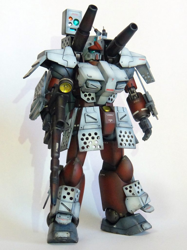 では、【バックストーリー】（長文です・・・）月刊「木馬」のインタビュー記事より皆様お待ちかね「燃える男の熱い特攻最前線」のコーナーです。私は今、東南アジアのとある前線基地におじゃましております。あそこにゴテゴテしたガンキャノンがありますね。それでは早速、その機体の主任技術者にお話を聞いてみましょう。（主任技術者）この機体な、何とか言うマグネットコーティングやってる博士が見たときな、「なんだね、これは！この重いのは！これじゃぁ素早く動けないではないか！」とか言いよってん。分かってへんわぁ、あの博士・・・素早く動けて何になんねん・・・がんばってちょっとぐらい速く走っても撃たれんねん。ジム見てみぃな。普通に撃たれてるやん。相手のザクかてそぉやろ。普通に撃たれてるやん。博士は「マグネットコーティングを施したガンダムの戦績は・・・！」とか言うてたけど、ガンダムは乗ってる人がおかしいねん。あれかて普通の人乗ってみ！普通に撃たれるて。大切なんは、ちょっとぐらい撃たれても大丈夫な頑丈さや。撃たれる前に撃ちまくる。それが生き残るコツや。うちら連邦やで。ジオンみたいな貧乏人ちゃうんやから玉はぎょうさんある。ちょうどパラシュートパックあったから、中のパラシュートほり出して、玉つめといてん。通常40発しか撃たれへんけど、こいつはガンガン撃てるで。テレビでやってたウイングなんちゃらのヘビーアムズがお手本や！でもな、武器とかあんま表に出したりぶら下げたらあかん。それ撃たれた誘爆するやん。最近、盾に武器格納したりぶら下げたりしてるのよぉ見るやろ？あんなん、ありえへんでなぁ。攻撃を防ぐ盾に爆発物付けてんねんで。自殺行為やろ・・・正面は防御一択や！あのガンダムかてな、腰の黄色いなんちゃらコアとか言うのん、撃たれやすそうなとこにつけてて、弱点さらしてどぉすんねん。酸欠なる前からおかしかったんやって、あの人。