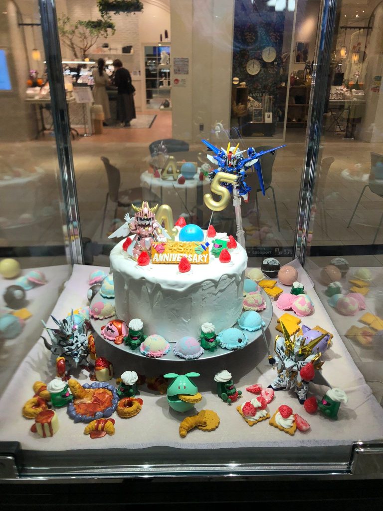 2024年10月にサークル出展した「ガンプラエキシビション・大阪会場」。私たち「遊限会社SDガンダム」は【GUNDAM 45th ANNIVERSARY PARTY】というタイトルで、色々な世界のSDガンダムヒーローがお祝いのケーキを囲んでいる展示をしました。