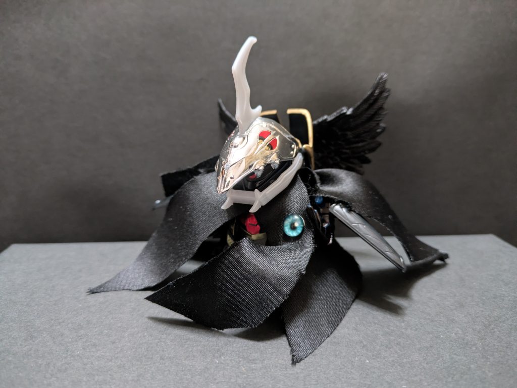 黒仔(くろこ)闇皇帝と同じく黒魔神の分身体。戦闘能力は低いが、魔黒眼を通じて対象の意識下に侵入したり洗脳したりできる。時空間を自在に行き来し、実体を持たないため光の結界内でも自由に行動できる。この制作中にホビーオフで偶然見つけたBB戦士の闇皇帝。新品だし…なんか運命感じて即購入。構想だけで作る予定していなかった黒仔を制作できました。素組みして余分なパーツはカット。100均で見つけたドール用の羽根を背負わせ、敢えて不均等に裁断したネクタイをマントのように纏わせました。