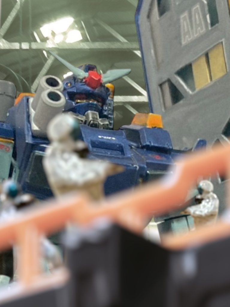 最悪の夢見で起床したのは、あの忌々しい”マリア”の”アメイジング・グレイス”のせいだ。 出来すぎている。 2度と戻らない妻子。2人が愛したあの歌が、今、流行歌としてそこら中から聞こえてくる。それを持ち歌にしている、バカな小娘が、自分の手を煩わせる。 こんなにも腹立たしいことがあるか――。「デニー大尉!」 いらいらしながらMSハンガーに向かって歩いていると、馴れ馴れしく名前を呼んでくるヤツがいる。マイセンにとって、名前を呼ばれることは逆鱗に触れるようなものなのは、同じ基地内にいる連中は知らないはずがない。いったいどこのどいつだ?振り返るマイセンの顔は、紅潮している。「デニー大尉、昨日の戦闘さすがでした!」 小走りで追いついたのだろう。息を切らしながら、細見の男が近づいてくる。向こうはこちらを知っているようだが、マイセンには誰か分からなかった。着ているノーマルスーツを見ると、一応、パイロットのようだ。顔はにこやかに微笑んで見えるが、目だけが笑っていないような、奇妙な顔をした男だ。マイセンの顔色にも、気づいていないようだ。「さすがです、やはり、ガンダムを任されている方は違う、と、皆が言っております!わたしの部隊も日夜厳しい訓練に励んでおります!」興奮して話すが、話の内容はぼんやりとして要領を得ない。「乗っている機体も、支持する兵の数も、この艦隊でデニー大尉に勝るパイロットはいませんよ!」どうやらマイセンのことを尊敬しているとか、そういうことを言いたいらしい。人様に敬意を表するのは大変結構なことではあるが、ここは戦場だ。本音なのかおべっかなのかは知らないが、興奮しながら社交辞令を述べているようなときではない。「おい。」 こちらの反応を無視して話し続ける相手の声を遮り、マイセンはドスのきいた声を出す。「まず、所属と、貴様の名を名乗れ。わたしは貴様のことなど知らん。」「し、失礼しました……!自分は、ケイン……」「それと、”デニー”と呼ぶな。それだけは、絶対に、だ。いいな?言ったぞ?2度と呼ぶなよ?」相手の名乗りなどまったく無視して、それだけを力強く告げ、マイセンは踵を返した。「……ルーキーですね、あなたのことをよく知らないと見える。」 いつの間にか、隣を華奢な男が歩いている。ローワン・ジョウ少尉だ。 マイセンが、ファーストネームで呼ばせていたのは妻だけだ。(わたしをデニーと呼んでいいのは妻だけだ。お前らはマイセンと呼べ。)新婚の頃は、自分で明るく吹聴していたが、コロニー落としで妻子を失ってからは、キラーワードだ。彼と一緒に務める連中は、その暗黙の了解を共有し合う。彼のことを、決して”デニー大尉”とは呼ばない。「褒めてくれるのは別に悪い気はしない。だが、自分の魂から出る言葉で語れないヤツは信用できん。」「何ですかそれ。」「階級章を見たが、下士官だ。下士官のくせに