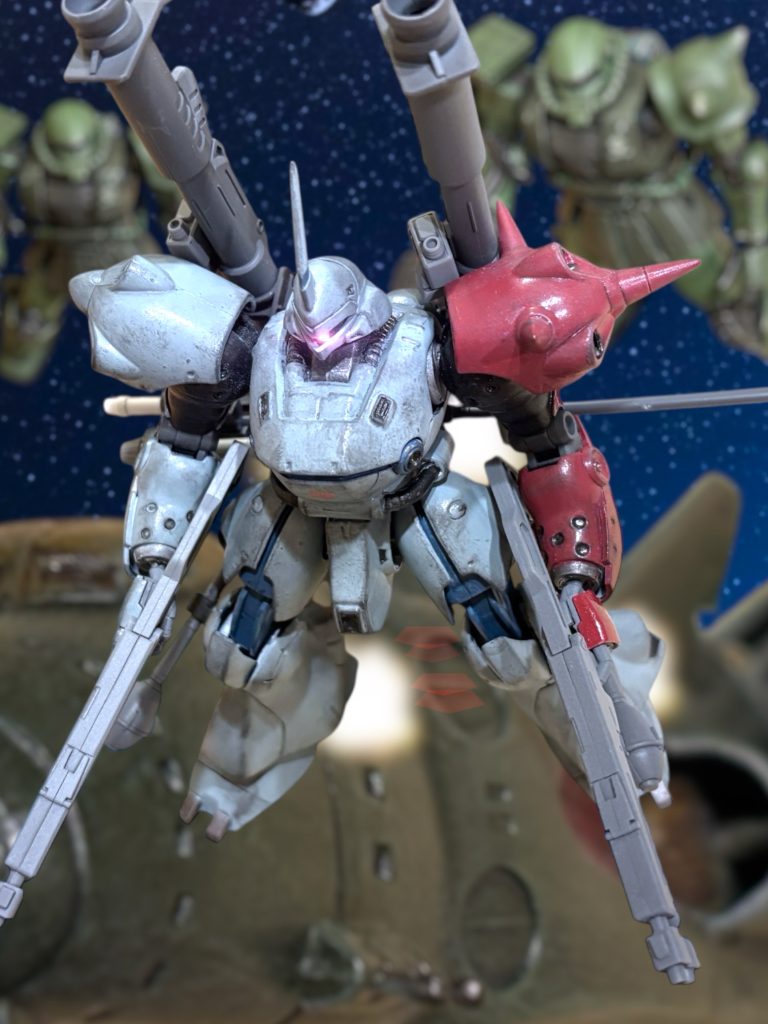 モニターを見ると、ザンジバルの傍にブルーグレーの見慣れない機体が見えた。左肩だけでなく、左腕全体を赤く塗り、ハリネズミのように武装を山積している。『新型…ここに来て!?』ローワンが言う。「だから言った……!」言って、マイセンは機体を先行させた。『大尉!』ローワンの声を無視して、マイセンはザンジバルに接近する。ブルーグレーの新型が、咄嗟に銃口を向けながら、進路を遮る。機体をぶち当てるようにして、接触通信を繋いでくる。『貴様、約束が違う!』 若い声だ。「どけ。」『何のつもりだ?』「艦を見せろ。このまま奇襲を掛けるつもりではないのか?」『何を馬鹿な……。』「1年前も、貴様らは……!」マイセンは、歯噛みする。『……1年前…?』「忘れたのか……貴様らっ!!」獣のように、咆哮する。『……コロニー落としか!?』「わたしの、妻子を、奪った……!」叫びながら、新型の敵機をつき飛ばす。