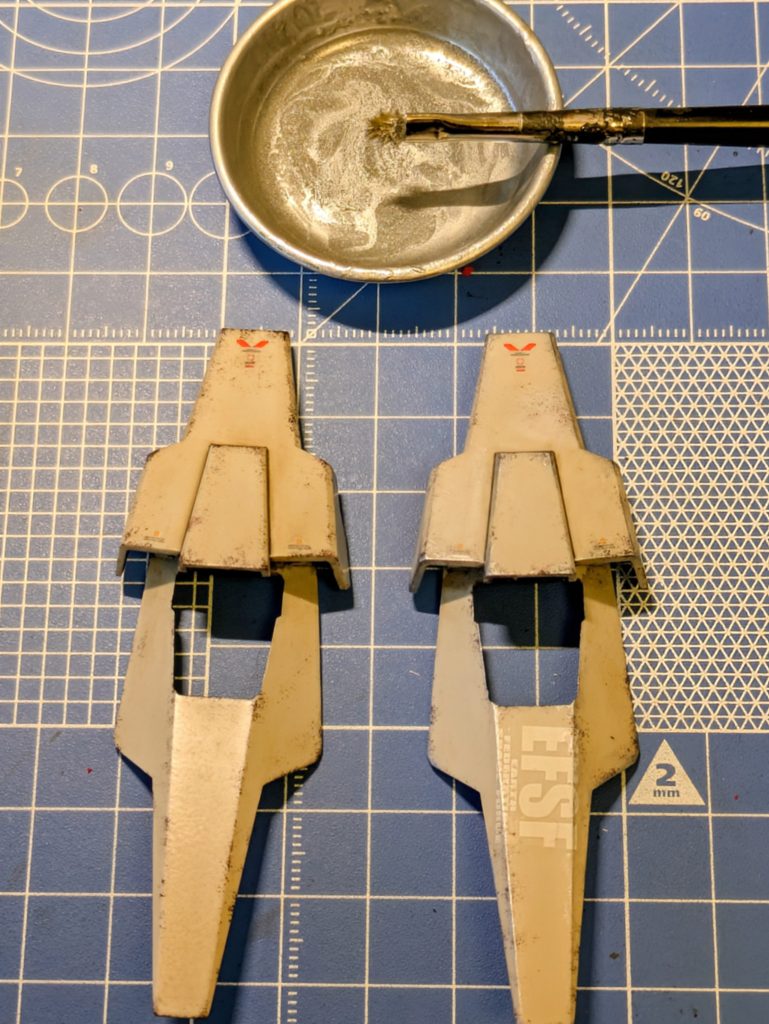 ③ドライブラシ(銀ハゲ)悩ましいのが、この工程。理屈っぽく考えると、そもそも、MSに使われるなんちゃら合金って、銀色なの❓️とか、金属は腐食するから、剥げたてホヤホヤじゃなきゃ、銀色にはならないよね❓️、1/144スケールで、こんなに銀ハゲが見えるもの❓️とか…でも、一番やった感が出る工程だから、「塗っちゃうんだなぁ〜コレが‼️」(ゾルタン風に…)エッジ(②で汚した場所狙い)に、銀塗料を含ませた筆をカッスカスになるまで塗料を落として(新聞に塗りたくって)から、擦り付けてます。写真の筆、もう、ボロボロで筆と呼べる代物じゃないですね。この工程だけEFSFの方がafterになってます。ゴメンなさい🙇‍♂️