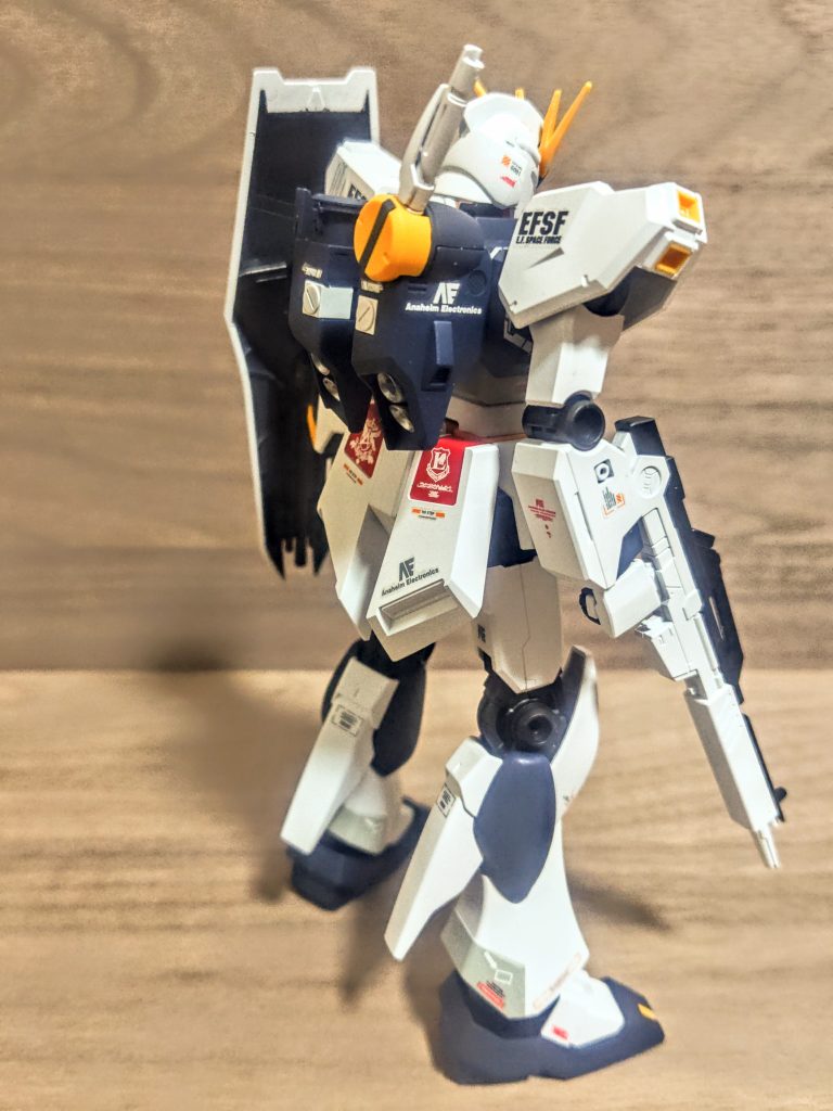 さて、このνガンダムがまた傑作。劇中でアムロが最後に乗ったガンダムですね。「逆襲のシャア」1988年の作品ですよ、素晴らしい。このνガンダムはアムロ自らが設計にも携わっていたはずですが、この機体は「シンプル」で美しいです。主人公機としてのガンダムは、マークIIが初代とほぼ同じイメージの方向性とデザイン。そこからゼータやダブルゼータで可変機としての新たなデザインとイメージの追加。そしてこのνガンダムで変形機構を全て捨てて原点回帰。この時監督はマントを羽織ったような新しいガンダムへ、と語っています。いいじゃないですか、生まれるまでの系譜が既にたまりませんね、人気があるのも頷けます。私としては初代の青と黄色と赤があったなら、このうち黄色を減らせば格好良くなると思っていますが、νガンダムは赤も減らし、黄色はオレンジへ、そして青は黒にと、「反則級にスタイリッシュなカラーリングで塗られてるっ(笑)」そりゃこれがナンバーワンです。