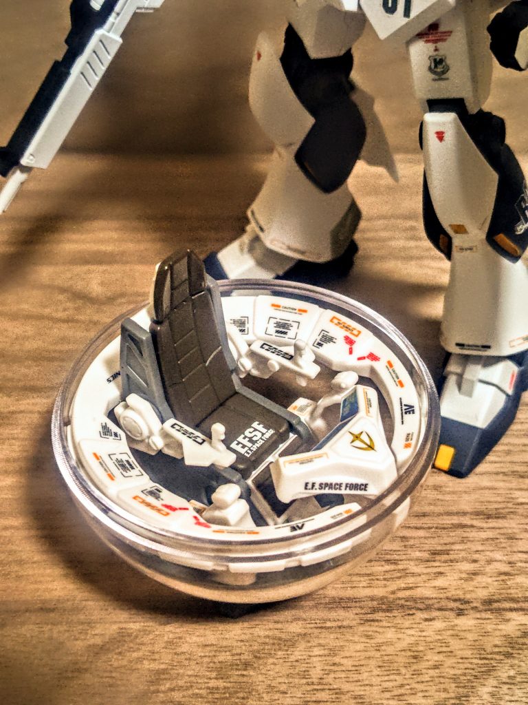 見比べるといかに最初のがシンプルに美しいかわかります。とはいえ私のはアナハイムエレクトロニクス製なので、ちょっと仕様が違うんですね。多分そうです、きっとそう。さて、こんな玩具も一緒に入れてあげると雰囲気が良くなるかもです。それではまずはカプセルに。