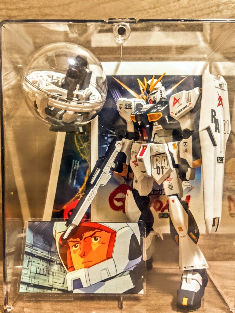 、、というわけで、しれっとアムロも入れておきましょ（笑）。この展示ケースを作ろうのコーナーは、まず本体が完成してからなので次回は本当いつになるやら。それでもせっかく作ったガンダム、上手く飾りたいですよね。皆さんもぜひ作ってみてください。思ったよりこういうのって作るの楽しいですよ。「コツーン」おや、こんなところに、何か落ちている。