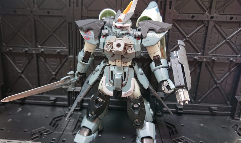 両腰のスタビライザーにより宇宙空間での機動性を向上。左腕にはシグーのM7070 28mmバルカンシステム内装防盾の試作であるM7049 23mmバルカンシステム内装防盾を装備。盾と射撃システムの両立を図っている。近接武器として、ジン同様のMA-M4 重斬刀を装備。両肩、胸部、膝に備えた増加装甲により耐弾性を向上。これらはオペレーション・ウロボロスに備えて、兵器としての耐久向上を図っていたものだが、最終的には連合からのPS装甲データ奪取により、陽の目を浴びることはなかった。