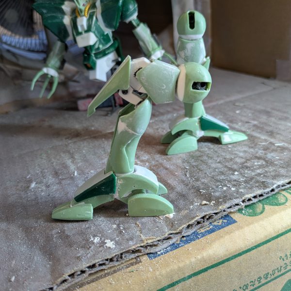 明けましておめでとうございます。ハンマハンマの脚部の改造は何とか出来ました。極力キットを使おうと、試行錯誤で、意外と時間が掛かりました。足先は、キットの造形が設定と全く違ったため、各部をバラバラにして、爪先は分かれているところを一体化し、足の甲はそのまま、踵は脇のユニットを幅詰めだけでそのまま、踵中央は形状が全然違ったので、角度を変えて成形し、角バーニアを接着、接続穴の出っ張りを削り飛ばして幅詰めしました。踵の足裏にはモールドプレートを貼ってあります。脛はふくらはぎスラスターの上のラインで切断し、下は幅詰め、上はくさび状に削ったプラ板をはさみ、上で2ミリ幅増ししてあり、下部と接着してパテで強引にラインを繋げました。腿と膝は検討した結果フレーム式にしました。可動は膝と腿のフレームを伸ばすことでいびつですが90度位曲がる事ができます。関節を組み込んだ都合で5ミリ位延長しましたが、元々伸ばす予定だったので、ちょうど良かったと思います。キットを設定に近付けるというテーマで作っていましたが、キットのパーツは、部分単位で見ると、案外設定に近い形状で、組み合わせの都合でモッサリしてしまう部分が多分にありました。多分ポリキャップを仕込んだり、金型の都合なんかがあったんだと思いますが、当時は厳しいスケジュールなどで、大変だったのかと思いました。現在、腕の大きさが気になり、小型化作業中です。結構難航しており、腰回りに着手するのに時間が掛かりそうです。切りの良いところまで出来たら、また投稿します。ありがとうございました。（5枚目）