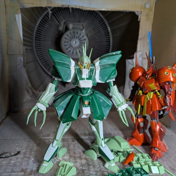 前回脚部の投稿をしましたが、この時は腕を小型化するため分割して幅詰めして接着し、パテ埋めまでしていて、乾燥待ちの状態でした。そこから整形できるまでかなりかかるかと思われたのですが、なぜか一発で形が決まってしまいました。そこで腰のスカートに着手したのですが、可動必須とはいえ、そこまで派手な可動域は必要なかったので、単純にスプリング接続でいいと判断して工作してみたら、これも短時間で出来てしまいました。試しに全身を組み上げてみたところ、思わずハンマハンマだ！と驚いてしまい、早く今まで見て頂いていた皆様に見てもらおうと思い、急遽投稿致します。後の工作は、導力パイプくらいです。足元のパーツは、各部バーニアで、塗装後接着するため分割しておいたものです。スカートは、バーニアを分割したあと、設定を参考に、下というか内側の部分をプラ板で追加造形しています。実は脚部はフレームを脛に挿しただけの状態なので、プラプラで直立させるのが精一杯でした。後はパイプを設置し、細かいディテールを追加すれば本体は完成なので、制作途中の投稿は最後となります。次は完成品を投稿しますので、暫くお待ち下さい。ありがとうございました。（2枚目）