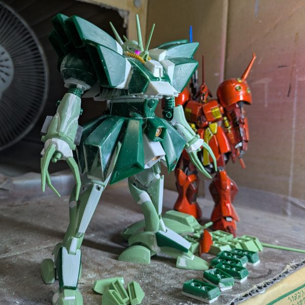 前回脚部の投稿をしましたが、この時は腕を小型化するため分割して幅詰めして接着し、パテ埋めまでしていて、乾燥待ちの状態でした。そこから整形できるまでかなりかかるかと思われたのですが、なぜか一発で形が決まってしまいました。そこで腰のスカートに着手したのですが、可動必須とはいえ、そこまで派手な可動域は必要なかったので、単純にスプリング接続でいいと判断して工作してみたら、これも短時間で出来てしまいました。試しに全身を組み上げてみたところ、思わずハンマハンマだ！と驚いてしまい、早く今まで見て頂いていた皆様に見てもらおうと思い、急遽投稿致します。後の工作は、導力パイプくらいです。足元のパーツは、各部バーニアで、塗装後接着するため分割しておいたものです。スカートは、バーニアを分割したあと、設定を参考に、下というか内側の部分をプラ板で追加造形しています。実は脚部はフレームを脛に挿しただけの状態なので、プラプラで直立させるのが精一杯でした。後はパイプを設置し、細かいディテールを追加すれば本体は完成なので、制作途中の投稿は最後となります。次は完成品を投稿しますので、暫くお待ち下さい。ありがとうございました。（3枚目）