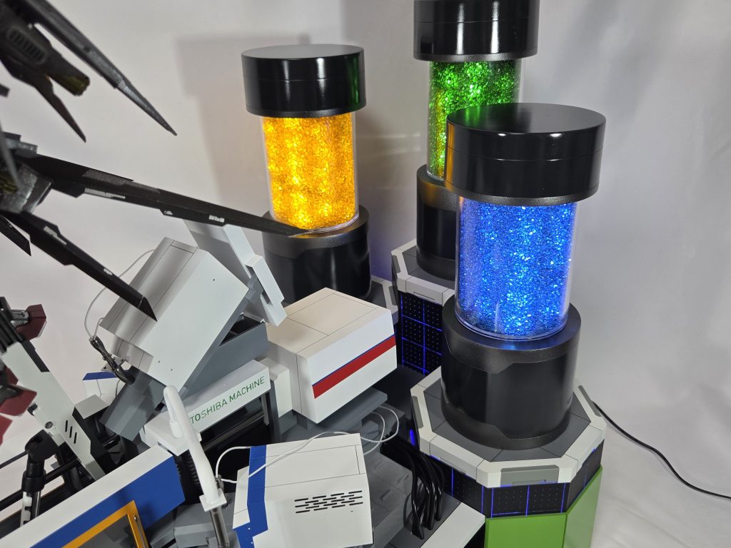 電動式４色射出成形機の後ろにはペレット（ガンプラの材料）を配置しています。