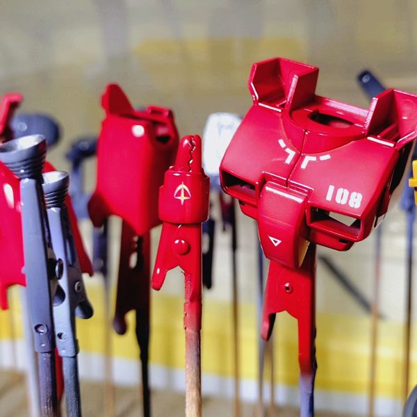 自作したバイオレットグレイを下地としてしっかりと厚塗りします。塗装の強度を上げるために、基本的にはサフを使用しないようにしています。そのあとに、赤い色にはブラウン、黄色にはオレンジなどの下地を塗装して白色などでハイライトグラデーションを入れていきます。その上に、下地が透けるように(クリアレッドなど)をつやが出るように塗っていきます。乾いたらスミ入れを行った後に、クリアを塗装しデカールを張っていきます。クリアを挟まないと色がデカールに滲むことがあるのと貼りやすくなるので、クリアを挟んでいます。最後にトップコートとしてフラットクリアをかけて完成です。（4枚目）