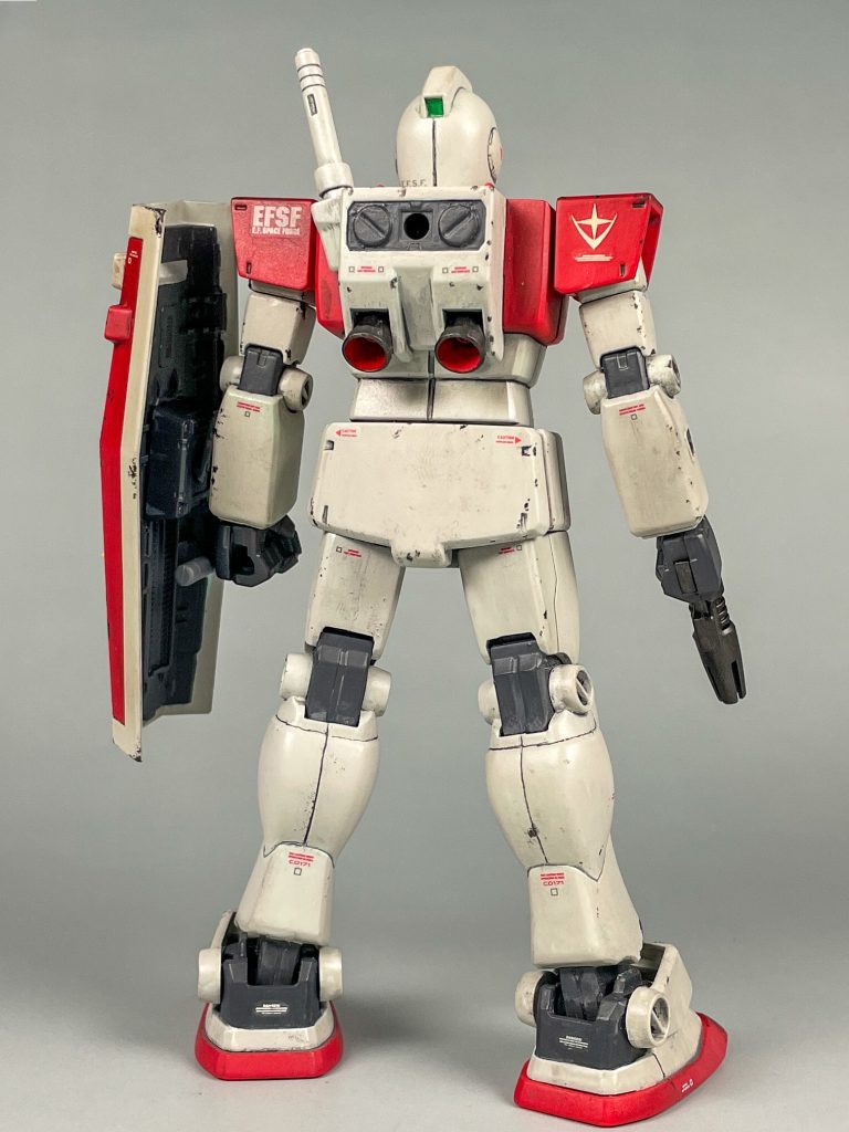 立ち姿。もう25年前のキットですが、ジム特有のシンプルなデザインをよく再現できていると思います。塗装は筆塗りによる全塗装を施しています。他にはスミ入れ、デカール貼り、ウェザリングを施してから、チッピング。トップコートにつや消しを吹いています。&nbsp;【使用塗料】本体赤：ガンダムアッセンブルカラー レッド本体白：水性ホビーカラー &nbsp;グレー FS16440本体黄：水性ホビーカラー ガンダムイエローシールド裏、関節部など：水性ホビーカラー ファントムグレーバーニア、ビームスプレーガン：黒鉄色