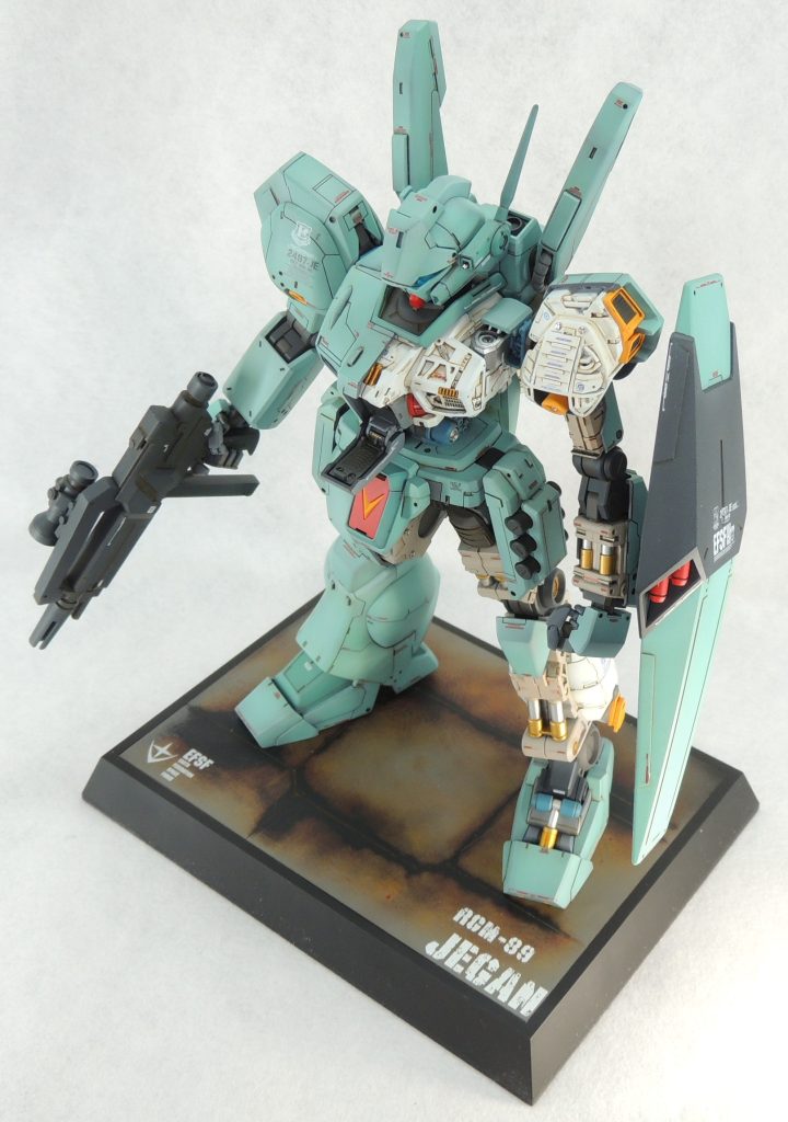 &nbsp;■台座　キットには台座が付属していないため、サイズ的に丁度良いタミヤのディスプレイベース・スモール(148mm×108mm)を使用しました。格納庫の一部に見立ててパネルラインのスジ彫りを入れ、下地をブラックサフで塗装した後、油彩によるドッティングにより複雑で奥深い色味を出しています。雰囲気としては、ラーカイラムの格納庫をイメージしています。使用したデカールは、地球連邦軍のエンブレムと”EFSF”は「ガンダムデカールDX」から流用し、文字はスジボリ堂のチッピングデカールを使用しました。