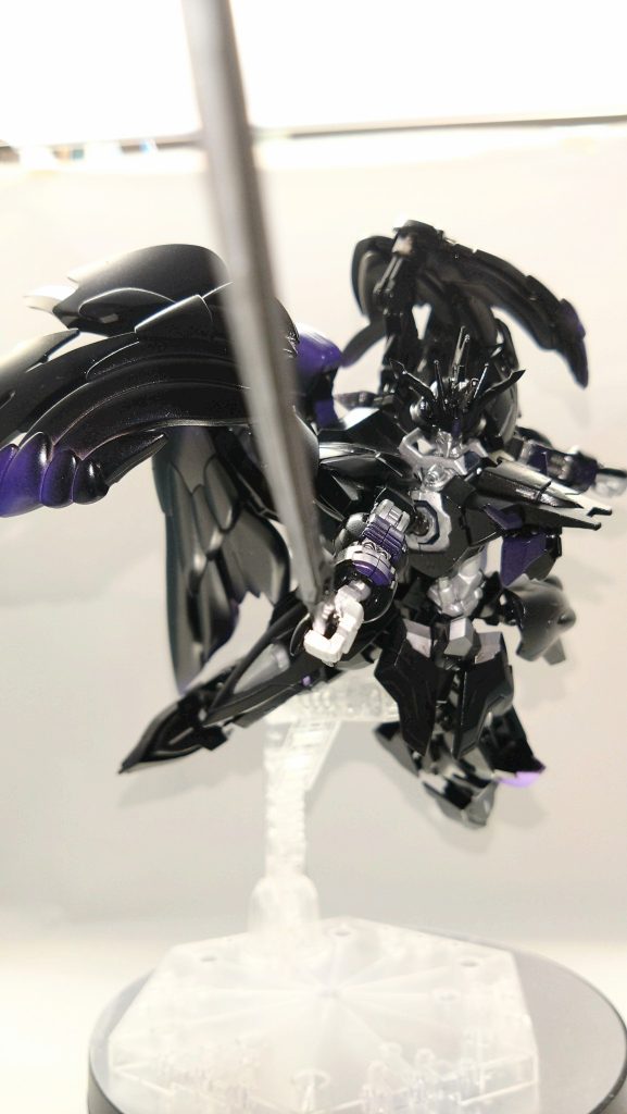 こうして幕を開けた決闘。デミトレーナー、ディランザの2種5機が専用格納庫から射出されフィールドに着く。「あれ？あいつの機体まだ出てきてなくないですか？」「まさか直前になって逃げたわけじゃないよな？あんなセリフ言っておいて...」「いや、あれを見ろ！」後方のデミ機に搭乗していた一人が仲間を静止させるようにそう叫ぶ。ガコンッと大きな音をたて薄汚れたコンテナが運び込まれ展開を開始する。「別に待ってなくていい。さっさと始めよう。」「なっ...！？」「どうなっても知らねえぞ！」「勝敗はモビルスーツの性能のみで決まらず」「操縦者の技のみで決まらず」「「ただ、結果のみが真実！！」」&nbsp;「先手必勝！」宣誓が終わると同時に後方役のデミ2機が砲撃を開始、前衛のディランザが一気に攻め込む。「いくよ。ガンダムイルシオン。一緒に。」「やはりガンダムに乗ってくるか。その呪われた光を見せやがれ！」リーダー格は着弾した砲撃の煙に向かってそのまま突撃をしていく。しかし、横のディランザ1機が突然頭部を破壊され機能停止する。何事かと横を見るとそこには実剣の黒い太刀が刺さっていた。煙幕の中から勢いよく飛んできて刺さったのである。「なっ！？実体剣だと！？」そう思ったのも束の間、ルナの機体はすでにもう1機のディランザを捉え、蹴りを入れていた。「うわぁ！」「威勢の割に遅いじゃん。これで本気だというの？？」煙幕の中から現れたその黒い機体の背中には大きな羽。相手も観客も見たことのない装備に目を奪われた。