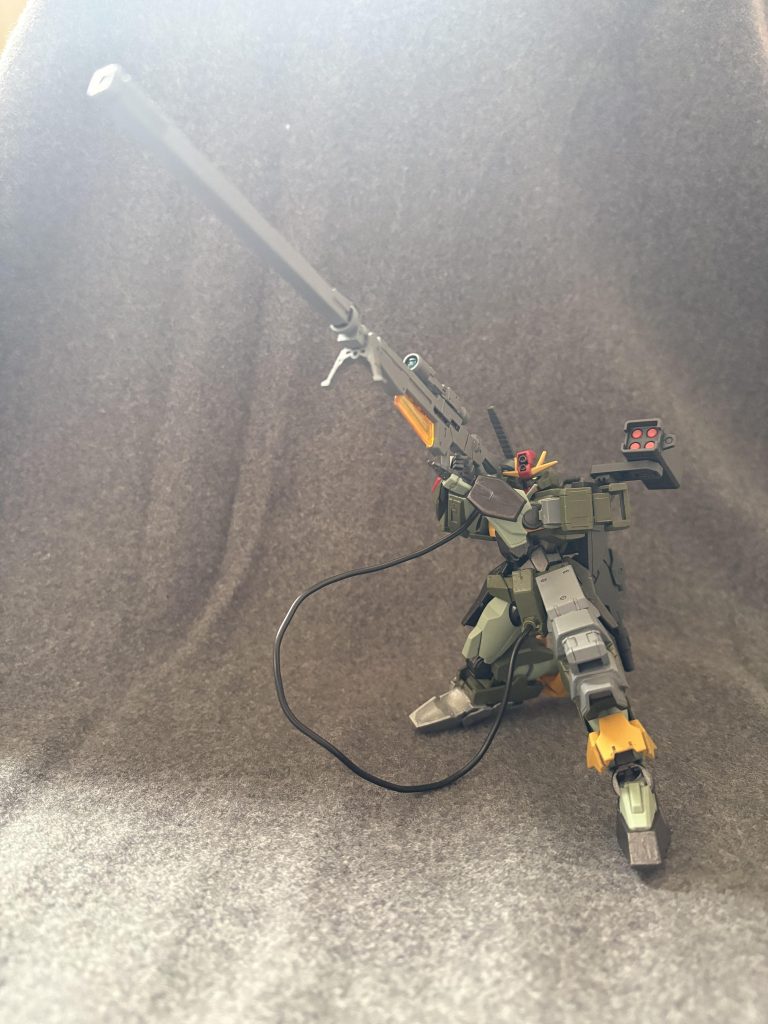 現地回収して左右非対称になった機体も好きなので肩や膝に追加装甲を盛り盛りにしました。膝立ちをさせ易くするためでもありますが…。武装はマウンテンサイクルからそれっぽいジャンクパーツを組み合わせて作った「対MS用超長距離GNスナイパーライフル」です。機体の股間部分からエネルギーワイヤーを供給して発射する設定です。ハルコ○ネンⅡ？バ○ターランチャー？……なんですかそれ？