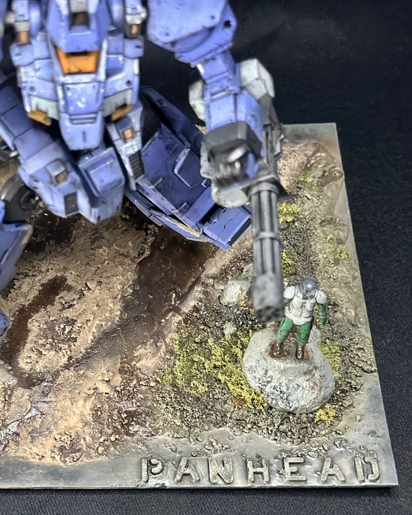 I created letters using epoxy putty and a stencil, and then painted them to look like rocks that blend into the scenery.