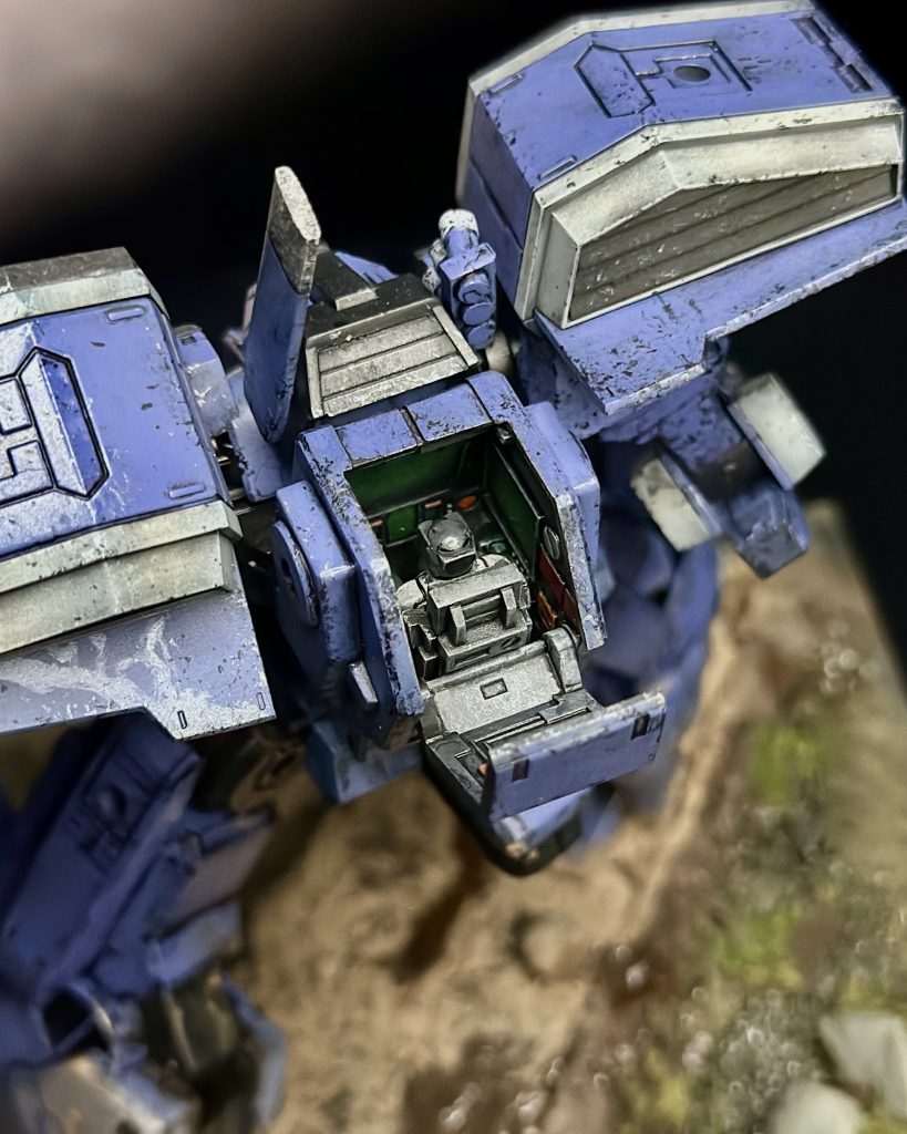 The interior of the cockpit is shown here. You can also see some of the recent rain water that is supposed to be dripping off of the mobile suit.