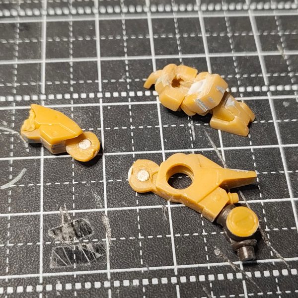 ガンダムアーティファクト第1弾のhi-νガンダムの下半身の改修①足首にＴジョイント（ガシャポンのＳＤガンダムに付属していたもの）を薄くし、受けをプラ板で作り、分割やクリアランス確保に削ったりし移植。前回はＢＪを移植したのですが、かなり面倒な作業だったので、ガンプラ的な感じでＴジョイントにしてみました。②膝は、前回同様に互い違いにしました。接続は今回はネオジムに変更。前回のネジでは、動かしていると緩む＆可動域が狭いのでネオジムにしました。③膝を曲げると赤い部分に干渉して全然曲がらないのです。④の右側参照。赤い部分を削除しプラスネオジムにしたことによって回転軸の中心がズレ④の左側参照まで曲げれます。この互い違いの接続だと膝のセンターで軸打ちすると後ろの動力パイプのディテールが邪魔して曲がらないのですよね～太もも側にクリアランスを作ると見た目が変なのでマグネットパワーでごり押しです(>_<)⑤、⑥腰回りのアーマーはすべてネオジムで接続。軸を入れると、もげたりするのでマグネットパワーで。サイドアーマーの受けは、ホチキスの針の角を使い、元の軸を接続で埋まる分をカットし、裏側からＬ字になるように接着。股間軸の可動は、ＢＪを移植。ＢＪの受け側の上側を保持力が無くならない程度除去し、足の開きの可動域を確保。2年前のハイニューの可動化は、自身初の可動化だったので可動域を気にすることなく可動をどうするかと試行錯誤でした。今回の改修は可動域ＵＰ←大した広くなってないけどね(>_<)（3枚目）