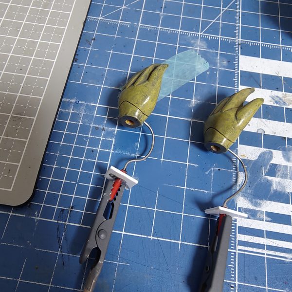 腕を刺し替えて、巡航モードに移行。肩アーマーの中の本体側の穴に刺す仕組み上、クリアランスがまったくなくて大変でした。1枚目のグリップで掴んでいる所を本体に刺して、掌は180度回します。（1枚目）