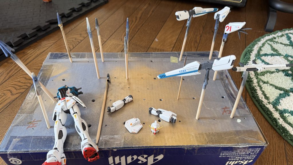 艶消しトップ吹いた後の組みつけの写真です。アサヒビール缶の入れ物を使って部品立てにしております。実は箱の中に、更に箱が入っていて、串を刺しても倒れないようになっております。なかなかの力作です。良いですよ(笑)!ガンプラ関係ねえ...。😅