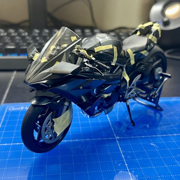 皆さま、明けましておめでとうございます。今回制作中のフラッグはコンセプト段階で可変機構をオミットする方向で進めていたため、長距離移動用のサポートメカ的なものがあればいいなと考えていました。そこで目を付けたのは戦闘機モチーフのNinja H2R、そうバイクです。フラッグ自体戦闘機っぽい意匠が多いので、Ninjaは結構相性が良いのでは？と思い、制作を進めています。バイクのプラモ自体は実は初めてということもあり、まだ仮組みが終わった段階ですが、塗装の関係上接着がほぼできない＋全然ハマらないビス止め(何度もビスを紛失しかける)という苦行を新年早々味わうことになりました。私自身バイクの知識が皆無なので、構造、部品云々はさっぱり分かりません。ということで今回は実車の設定ガン無視で制作を進めていきます(かっこよければそれで良し)。改造としては基本的に見た目が大きく変わる改造…というよりフラッグに合わせて形状を調整&ビス固定をなるべく減らす改造がメインとなります(サイズ感はピッタリなので)。その他、武器を懸架できるようにするとかアクションベースで固定できるようにするとか色々検討中です。長文失礼しました。それでは今年もよろしくお願いします。（3枚目）