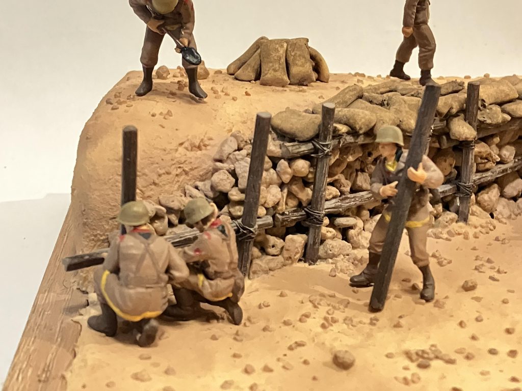 盛った土が崩れてこないように、丸太を組んで石を積み、その上を土嚢を敷いて銃撃や爆風を防ぐ感じで(//∇//)丸太は、より線を使って縛りました縛るの地味に掛かった💦丸太はタミヤの1/48を使用しましたが、1箱では足りなかったから、足りない分はランナーを使ってノコで傷付けて皮を再現兵士3人で柵を組んでいる様子です&nbsp;