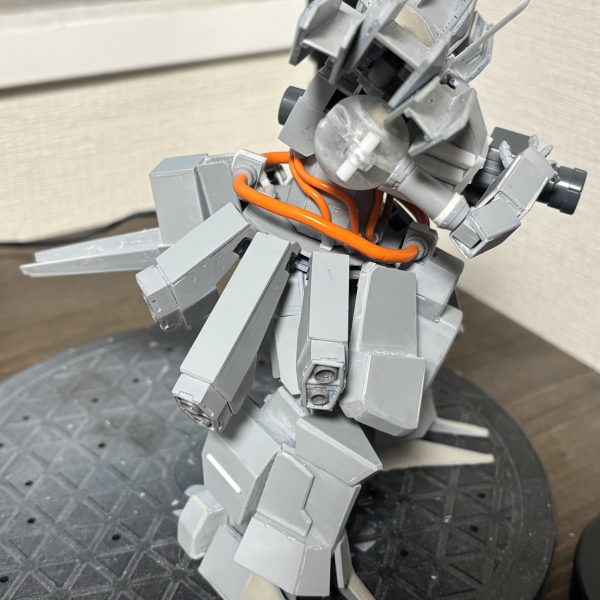 テイルのスカートをデカめにして取り付け、もっと本来は斜め下なんですが飛び出した形にしてます。腕は二重関節化してとりあえず稼働域を確認してます。こっから下腕部にアーマーを作り込んでいく感じにします。適当に転がってたネットランチャー持たせてます。（3枚目）