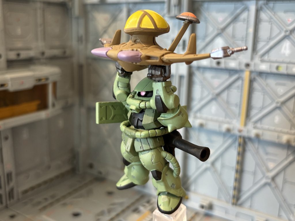 「いっちょ、コンバージで再現したろか！」ってことで再現したのがコチラ。「絵になる！映える！」と感じたモデラーも他にいたようで、既にコンバージで私なんか足元にも及ばない超絶クオリティで工作された方もいましたが、私としてはお手軽ちゃんでここまでです。ザク的には地球の重力下でルッグンに釣られてるわけやから、足首以下は少しダラ～ンとしてる事。あと、シールドも少しダラ～ンとしてる事にこだわりましたよ。ルッグンの取り付けたザクの「持ち手」は、コトブキヤさんのパーツを使いましたよ。これは後から塗り塗りです。