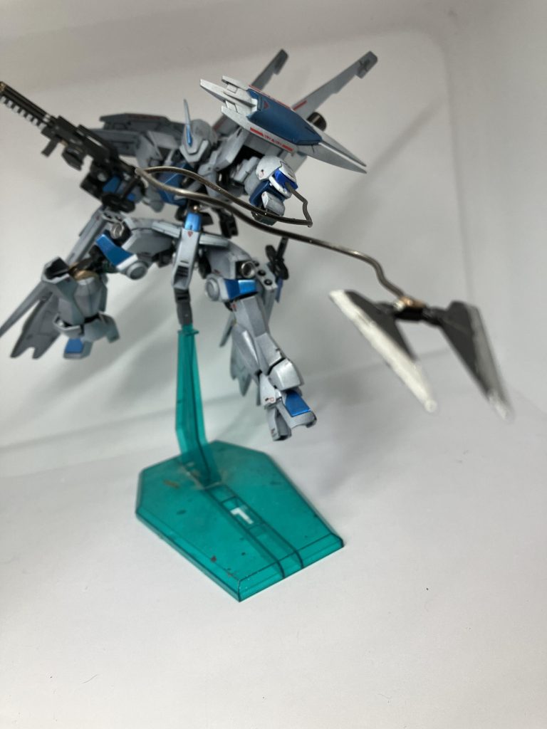 ライフルとワイヤークローを装備。脚部大型スラスターにマウントされているバエル・ソードは模造品であり切れ味も低い為、基本的に打撃武器として用いられている。