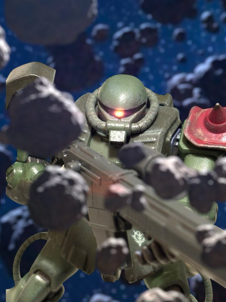 （戦う気がないのなら、白旗でもあげて見せろ。）　マイロは、胸の内で毒づきながら、対艦ライフルを構えた。（遠いな……。）　徹甲弾と炸裂弾を装填されたライフルは、ルウムの戦いでも何隻もの戦艦を葬ってきた、ジオンの必殺兵器だ。だが、その有効射程は５００ｍ程度。慣性の働かない宇宙空間なら、やり様次第ではもっと先まで届かないでもないが、マイロにはそれをやる自信はない。有視界モニターの隅には、イアンのザクも見える。　しばし、奇妙な静寂が続いた後、ノイズまみれの通信から、僅かに音楽のようなものが聞こえた。「……！？」　途切れ途切れに聞こえたその音は、女の歌声に聞こえた。『……何だ……？』思わず、声を上げてしまったのだろう。イアンの声が通信に入る。敵とこれだけ接近しての通信は、ミノフスキー粒子下でもこちらの場所を知らせる危険があり、普通は避ける。だが、そのことを忘れさせるほど、その通信は奇妙だったのだ。　味方の通信もノイズにまみれるほど、粒子に汚染された宙域に、突如、新たな熱源の接近を知らせるアラートが響く。　マイロは、咄嗟に視線を巡らせる。サラミスの艦上に突っ立っていた”のっぺらぼう”こと、地球連邦軍の主力MSジムが、動揺したように艦からふわりと浮き上がる。アビーと、一緒に出撃してきていた小隊のザクが、マシンガンを放つ。当てるつもりのない、威嚇射撃なのは、誰が見ても明白だった。しかし、新たに後ろからやってきた増援は、それに応じるようにビームを放った。