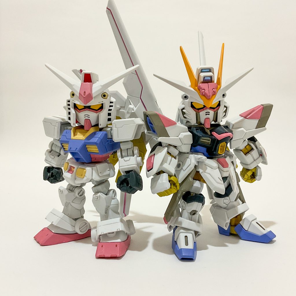 【レギュラー出演のガンプラ】　SDガンダムクロスシルエットのRX-78-2ガンダムとマイティーストライクフリーダムガンダムです。いずれもクロスシルエットフレームを仕込んでいます。基本成形色で、赤青黄などを水性ホビーカラーHJ（セイラマスオ氏監修カラー）で塗装しています。　普段の塗装は大体筆塗りです。エアブラシ（SPARMAX FLYER-SR2）を所有していますがコレであまり色は塗っておらず、ほぼトップコート専用で使っています。クレオス プレミアムトップコート UVカットスムースクリアー（つや消し）を吹き付けると大抵の塗装ムラは隠してくれますが希釈倍率が自分の中で定まっていません。永遠に条件検討の旅を続けることになるでしょう・・・　ペールトーンの色調がとても気に入っています。これを機にかわいがっていただけると幸いです。https://gumpla.jp/sd/2264449https://gumpla.jp/sd/2303750