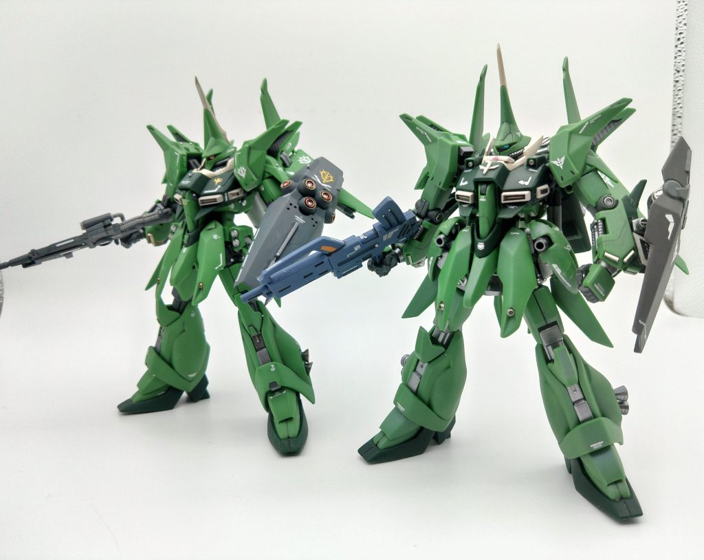 量産型との比較肩のマシンガンと丸い腰アーマー、襟のガードパーツの追加でガッシリとした力強いシルエットになっている。袖付きバウの色味は量産型バウと比べるとややグレーがかっているので、成型色の上からパープルパールをふいてやや暗めになるように調整しています。また、騎士の機体にコストを省みないハマーンネオジオンに対して、常に資金難の袖付きというイメージなので、派手なデカール表現は袖付きバウではそこそこに抑えました。袖やエングレービングを食わない程度に、かつ寂しくないぐらいのバランスを狙っています。