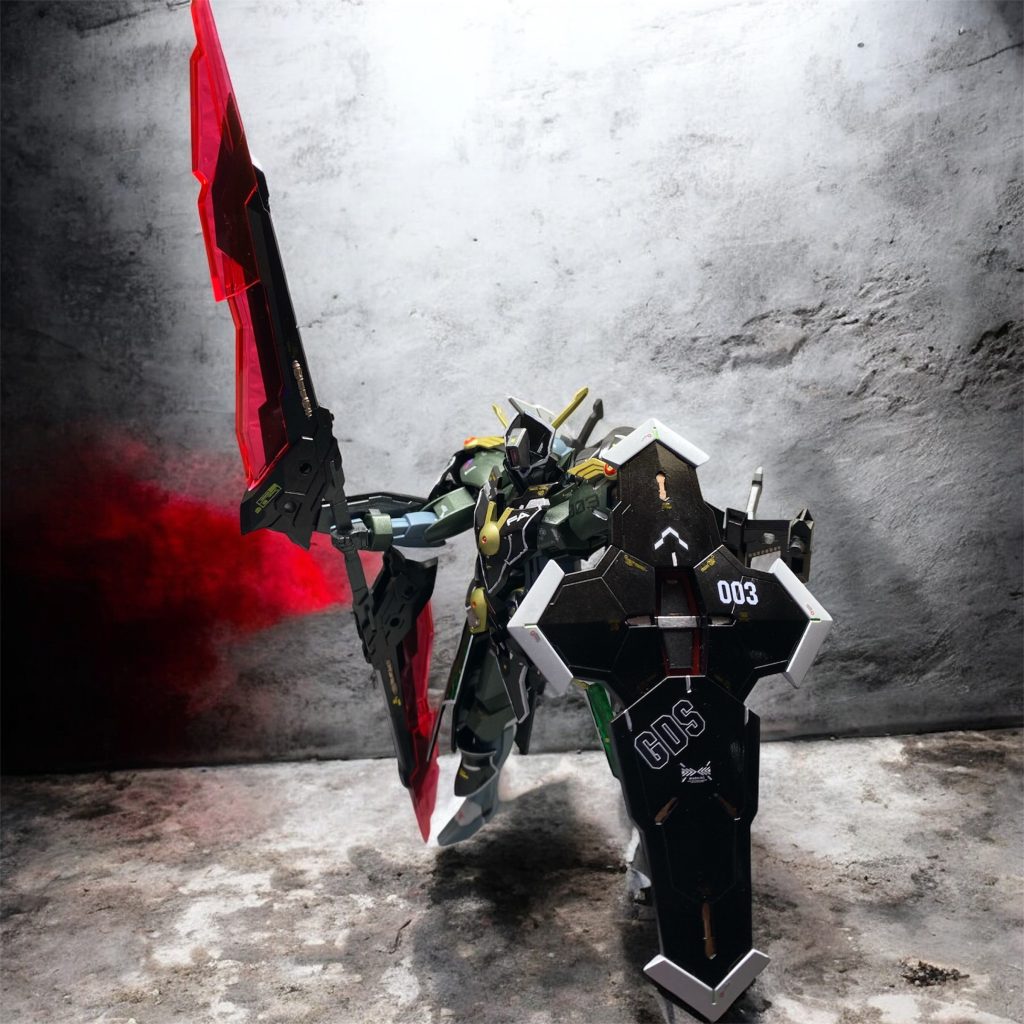 【機体解説】&nbsp;CFK-029FA&nbsp; ミカエリス・ノームは漆黒の騎士の駆る専用MSである。ベース機となっている旧グラスレー社のミカエリスは第5世代のGUNDフォーマット非搭載MSであったが、同社もまた他のベネリットグループ御三家の動向を察知し、秘密裏にGUND-ARMの研究を開始していた。通常、GUNDフォーマットは、MSのフレームなどの根幹部に設計段階から組み込まれる事が定石であったが、グラスレー社は、MSの増加装甲にその機能を持たせる事で、自社のGUNDフォーマット非搭載機にも、ガンビットの運用能力などを後付け的に付与する方向性を模索した。その結果開発されたのが、GUND-armorであり、本機はこれを装着したミカエリスのフルアーマープランとしてロールアウトしたものである。