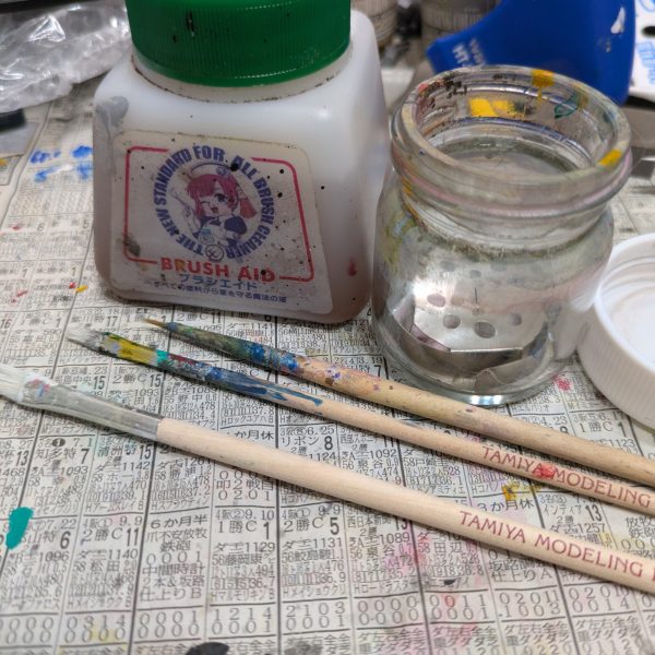 こんばんは。新宿の種馬こと、まお大佐です。GUNSTA様内で繋がれているバトンがのびおさんから私のところに回って来てしまいました。どうしよう。何も技術なんてないのに・・・。バレーボールおじさん→ますらおさん→meg-oceroさん→@244さん→Kaishi-Denさん→TFX-063さん→つぐおさん→押忍やすじろう→T-Non→yasaさん→FILOさん→kazzさん→max.さん→まお大佐2026年2月21日（土）AM5 :30 某所。私はMGフルアーマーZZ購入の列に並んでいましたー。ZZファンを自認する私にとってはマスト購入アイテムなのです。※FA-ZZです。FAZZは別機体です。そこんとこヨロシク！寒空の中購入待ち列で待機中、バトンの内容を考えていました。（思えばガンプラブームの頃も並んだことがあったなー、と思い出しました。その時に買ったのは「武器セット」（笑）でしたが・・・）参考に今までの走者の方々の内容を再確認します。『みんな上手ぇーよー』『私から伝えられることは何もない』と自問自答する時間が経過します。迷うこと2時間（開店時間まで後3時間なので時間潰し（爆）にはなってるのかな？）、ようやくヒントが頭の中を稲妻が走ります（効果音はもちろんNTのアレですよw）。GUNSTA様での企画「2025年年末紅白」がありましたよね。ここでAIが私の自己紹介（分析？）をしてくれました。『旧キットから最新キットまで色々作る雑食モデラー(一部脚色w）』うーん、コレだね。それともう一つー。その時に白組として参加し、皆様から評判の良かった『一人オペレーションメテオ』で登場機5機の内、4機を1週間で作ったということでお褒め（なのかな？）の言葉を頂けましたので、普通はじっくり丁寧に作ることが上達の道かと思いますが、こんな考え方もあるよね？くらいで流していただけますでしょうか。というわけで、【約1週間でガンダムキャリバーンとガンダムルプリスを作る】という自分本位企画を展開させていただきます。前置き長くてスミマセン。もう少し語らせてください。実は氷山の一角のマウンテンサイクルをなんとかせねばならないので、じっくり作るより、大体できればいいや、というのが本音です(ダメだろ？）。今回も筆塗りで行きます。【道具の説明】筆塗りで使っているのは特別な筆ではなく、田宮から出ている1本200円くらいの筆です。一応同じものを白用とその他用で持っています。ブラシウォッシャーで筆を洗ってあげるとリンス効果というか筆が長持ちします。洗うときは自分が使っている塗料(水性系、ラッカー系などの専用の溶剤をこの瓶に入れて洗ってください。水性なら固まる前なら水で十分です。ブラシエイドは今日はもう塗らないという時に筆をコレで洗い、水で落として乾かします。最近はブラシエイドを見かけないですね・・・。【ランナー塗装】ランナーから切り取ってからヤスリをかけたりして仕上げてから塗るのがセオリーだと思いますが、無改造のままならサフを吹く必要も感じませんし、先に切り取る前に塗った方が時短になります。エアブラシを吹く時は、パーツごとに塗装しますが、裏面などを塗る場合は改造をしなければ先にランナー塗装した方がラクじゃないすかね？パーツ紛失も防げますし・・・。ランナー塗装が終わった画像です。塗ってる？と思われるかもしれませんが塗っています。水性ガンダムカラーで整形色に近い（同じ？）ので写真だと分かりにくいですね。筆ムラも出ていますが、気になったらまた塗り重ねますので。OKOKw（こんなので良いのかな・・・。うーん）今夜は戦利品を抱きしめて寝ます。（6枚目）