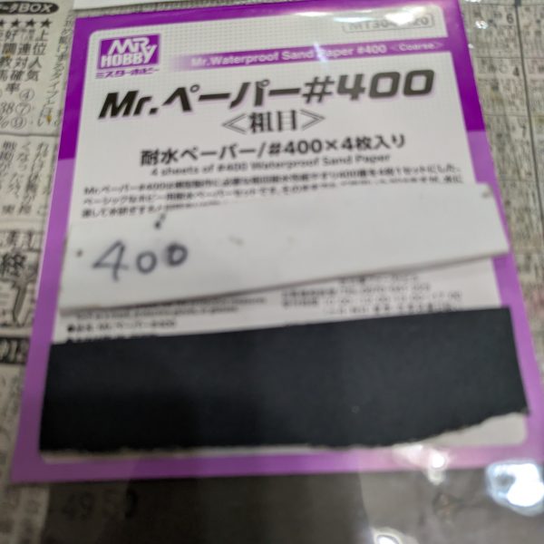 手を抜くのを推奨するのはプラモ制作としてどうなのでしょうか?手を抜くという表現は止めます。自分なりに愛情は注いでいますので・・・。良い例えがありました。料理愛好家の平野レミさんをご存知ですか?私もあの方の料理へのアプローチに準え、ガンプラ愛好家という事にします。モデラーっていうとなんか敷居上がっちゃいますからねwさて続きです。【ランナーからの切り離し】 とりあえずランナー塗装を済ませました。たまに思うのですが、パーツの裏面の色ってドムなら赤だと思いますが、他のMSって大体黒に塗ることが多くないですか?車のボンネットの裏も大体ボディと同じ色じゃないですかね?なので今回は裏面は塗らないです。では、ランナーから切り離しする前には何もしないかというと作業はします。モールドの掘り直しです。使う道具は100均のです。画像の赤い部分はキットに元からあるモールドです。青い方は特にモールドはないですが、掘っておくと墨入れが映えます。赤い方だけでも効果があります。切り離す時はプラモ用の鋏でざっくり切って、精密度の高いニッパーで余分を切るニ段階で対応します。仕上げ用のニッパーは私の持っている工具の方では高めです。ゴッドハンドの片刄ニッパーは壊しそうなので、タミヤのを使っています。3,000円〜4,000円くらいのです。正直高いかと思いますが、ゲート跡を綺麗に処理できるので、作業効率を格段に上げてくれる超便利アイテムなので、ここは頑張って買いましょう。塗装派も無塗装派も同じです。ちなみに私のタミヤニッパーは2代目です。初代は15年以上頑張ってくれました。中のバネが切れました。バネを入れれば復活するかもしれませんが、引退させて道具箱の中で眠っています。【合わせ目消し】ガンプラの大体の宿命として武器の合わせ目ですかね。基本モナカ構造なので、どうしても合わせ目が生じます。特に今回のように長めのライフルは特に合わせ目が発生しやすいです。ここはランナーを見た時から覚悟していました。(合わせ目消しのやり方)1.両面に接着剤(タミヤの白瓶)をドバッと塗り、塗ったあと1〜2分くらい待って「おりゃー」の掛け声と共にくっ付け、接着剤をムニュッとはみ出るまで圧着し、十分に乾燥(1週間なんて言いますね)させてからヤスリで削る。このやり方が一般的ですが、時間がかかるので今回は不採用です。2.合わせ目をそのままにする.変な話、合わせ目上等であれば無視していいかと思います。架空兵器なので、我々がおかしいと思っている合わせ目ですが、実は普通のことなのかもしれないからです。だからどうした!と思えば作業時間は大幅に短縮できます。3.段落ちモールドにする.ここで画像を紹介できませんが、筋彫り堂から出ている段モという工具を使うと段落ちモールド化させて分割線(合わせ目)を有効活用する。4.プラ板とかプラ棒を使って誤魔化す。プラ板を貼ったりして合わせ目を隠しちゃいます。私は最近は3と4の手段を使います。ということで画像はないですが、武器を早めに作っておく事にしました。説明書では武器は比較的最後に作ることが多いですが、最後に合わせ目消しが来ると萎えるので、私は複数を一気に作る時などは先に武器から作ったりします。ちなみにヤスリは水研ぎにしています。削りカスがヤスルと結構出ます。塗装の時よりも気を使ったほうがいいと思います。私はガスマスクみたいなのをつけています。間違って付けたままで宅配便を受け取りに行ったらびびられましたwその3へ続くー。(キャリバーンはバックパック以外は組めています) (3枚目)