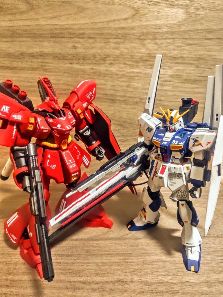 それではお気に入りのνガンダムと。こちらは福岡νガンダムなのでオリジナルカラーではないんですが、お気に入りの最高対最強という事で。どちらもアナハイムの機体です、サイコミュ、サイコフレームの技術をキャスバルがアナハイム、アムロ側に流し、その結果生まれたのがνガンダムという、ある意味兄弟機。スペック的にはサザビーの方が完成されていたようですが、結果は史実の通りです。さぁ、こうして並べてみると、やっぱりサザビーのボリューミーでグラマラスなフォルムは美しいですねぇ。あとね、赤いモビルスーツはやっぱり孤高の存在。そしてやはり曲線、曲面が組み合わされたまさにレーシングカーのよう。対してνガンダムはやっぱり直線がメインに感じますね。ポルシェとハコスカみたい、ってわかる人少ないですか。連邦とジオン、この場合はネオジオンですが、この2機がその対比を見事に見せてくれているようで、面白いです。