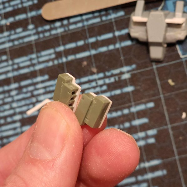 正直に言うと、これは見た目よりずっと大変でした。まず、側面の丸い光学部品を切り取りました。それから、プラスチックのプレートを使って胸部を拡張したらすごくクールになるんじゃないかと思いつきました。スーパーカーのフロントみたいに。穴も隠せるし。両側の形を合わせるのに、何度か試行錯誤して何度も切り込みを入れました。すごく小さくて扱いにくいんです。それから、装甲ブロックを胸部に貼り付けようとしたのですが、ブロックの裏側の表面積が足りなくて接着できませんでした。そこで、裏側にプレートを追加して滑らかな表面を作ることにしました。一応はうまくいきましたが、壊れやすいのではないかと心配です。とにかく、いい感じに仕上がったと思います。結果には満足しています。Let me tell you, this was a lot harder than it might seem.I started by cutting away the round optics from the side. Then I thought it would be cool as hell to extend the chest with some plastic plate. Kind of like the front of a super car. It would help to cover the hole too. It took me a few tries and lots of cuts to get the shape matching on both sides. They're so tiny and fiddly. I then try to stick the armour blocks to the chest but theres not enough surface area of the back of the blocks to adhere to. I decide to add plates to the back and create a smooth surface. It kind of works, but I'm worried they might be fragile.Anyway, I think it's looking good. I'm happy with the results. (4枚目)