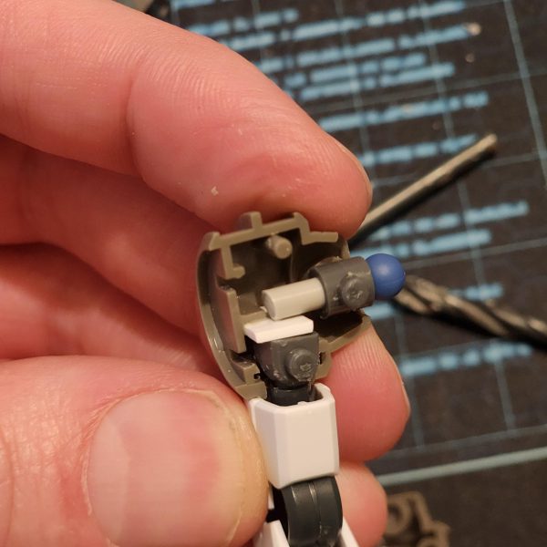 簡単にバランスをチェックして、いくつか変更することにしました。脚部については当初考えていたアイデアは却下になりました。作る手段がないからです。脚部に穴を開けて装甲を差し込むという簡単な方法を選びました。これで満足しています。GN-Xについて少し調べた後、翼だと思っていたものが実はデフレクターシールドだと気づきました。デフレクターシールドは廃棄し、バックパックを少し厚くすることにしました。デフレクターシールドを接続する唯一のパーツはとても小さいので、穴がかなり深いので中のパーツが失われるのではないかと心配でした。これが起こらないように、端にランナーエッジを貼りました。最後に、腕と肩に問題がありました。ポリキャップが肩の中で動き回っていました。これを解決するために、バリアとして機能するプレートを内側に貼り付けました。全て組み立てた後、とてもスタイリッシュに見えると思います。次は塗装の準備としてプライマーを塗ります。I conducted a quick balance check an decided to change a couple of things. The original idea I had for the legs went out the window, I just dont have the means to create that. I opted for an easier method of drilling a hole into the leg and pluggin the armour in. Im happy with that. After reading a little about the GN-X I realise what I thought were wings are actually deflector shields. I chose to scrap them and bulk up the back pack some more. The only part I have to connect them is so small I was worried of losing the piece inside the holes as they are quite deep. I stuck some runner edge onto the ends to stop this from happening. Finally, I was having issues with the arms and shoulders. The poly cap kept moving around inside the shoulder. I remedied this by applying some plate inside to act as a barrier. After putting it all together I think it is looking stylish as hell. Now it's time to apply a primer ready for painting. (4枚目)