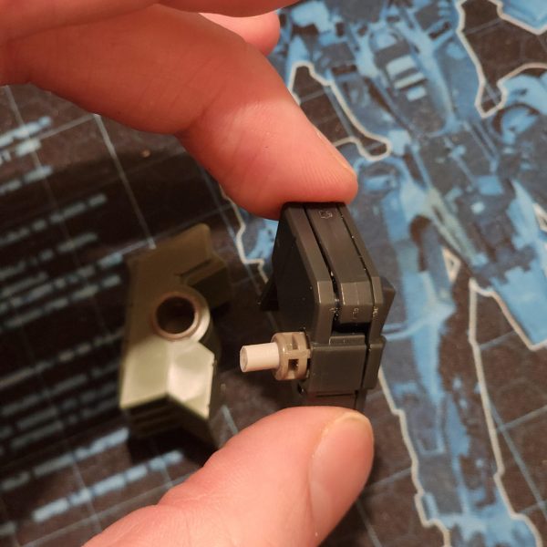 簡単にバランスをチェックして、いくつか変更することにしました。脚部については当初考えていたアイデアは却下になりました。作る手段がないからです。脚部に穴を開けて装甲を差し込むという簡単な方法を選びました。これで満足しています。GN-Xについて少し調べた後、翼だと思っていたものが実はデフレクターシールドだと気づきました。デフレクターシールドは廃棄し、バックパックを少し厚くすることにしました。デフレクターシールドを接続する唯一のパーツはとても小さいので、穴がかなり深いので中のパーツが失われるのではないかと心配でした。これが起こらないように、端にランナーエッジを貼りました。最後に、腕と肩に問題がありました。ポリキャップが肩の中で動き回っていました。これを解決するために、バリアとして機能するプレートを内側に貼り付けました。全て組み立てた後、とてもスタイリッシュに見えると思います。次は塗装の準備としてプライマーを塗ります。I conducted a quick balance check an decided to change a couple of things. The original idea I had for the legs went out the window, I just dont have the means to create that. I opted for an easier method of drilling a hole into the leg and pluggin the armour in. Im happy with that. After reading a little about the GN-X I realise what I thought were wings are actually deflector shields. I chose to scrap them and bulk up the back pack some more. The only part I have to connect them is so small I was worried of losing the piece inside the holes as they are quite deep. I stuck some runner edge onto the ends to stop this from happening. Finally, I was having issues with the arms and shoulders. The poly cap kept moving around inside the shoulder. I remedied this by applying some plate inside to act as a barrier. After putting it all together I think it is looking stylish as hell. Now it's time to apply a primer ready for painting. (6枚目)