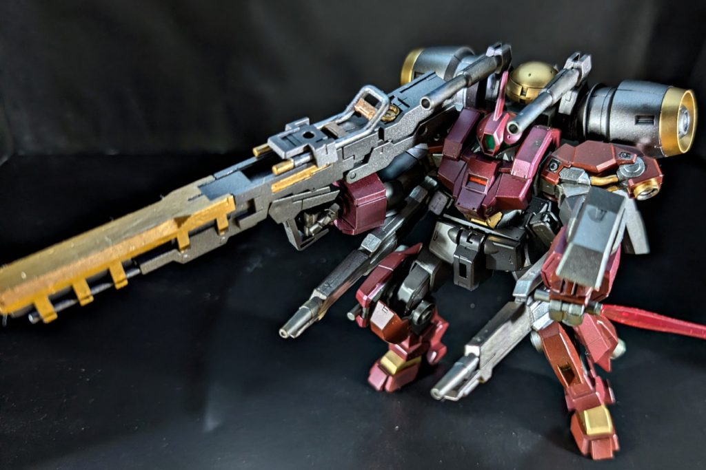 両腕にガトリングガン、腰に二門のエネルギーパック式ビーム砲、及び、主武装として大型バズーカを装備。ビームサーベルは可動域や武装を鑑みてサイズダウンされている。開発者曰く、『ここまで弾幕張れる機体で、これ(ビームサーベル)が届くところまで接近されるアホは救いようがn(略)』&nbsp;&nbsp;いずれも携行型弾薬を使用している為、戦闘中に状況に合わせてパーツをオミットする事が出来る。(なお、それらを外すとサーベルサイズが小さめなデミバーディングと同様の機体になる)